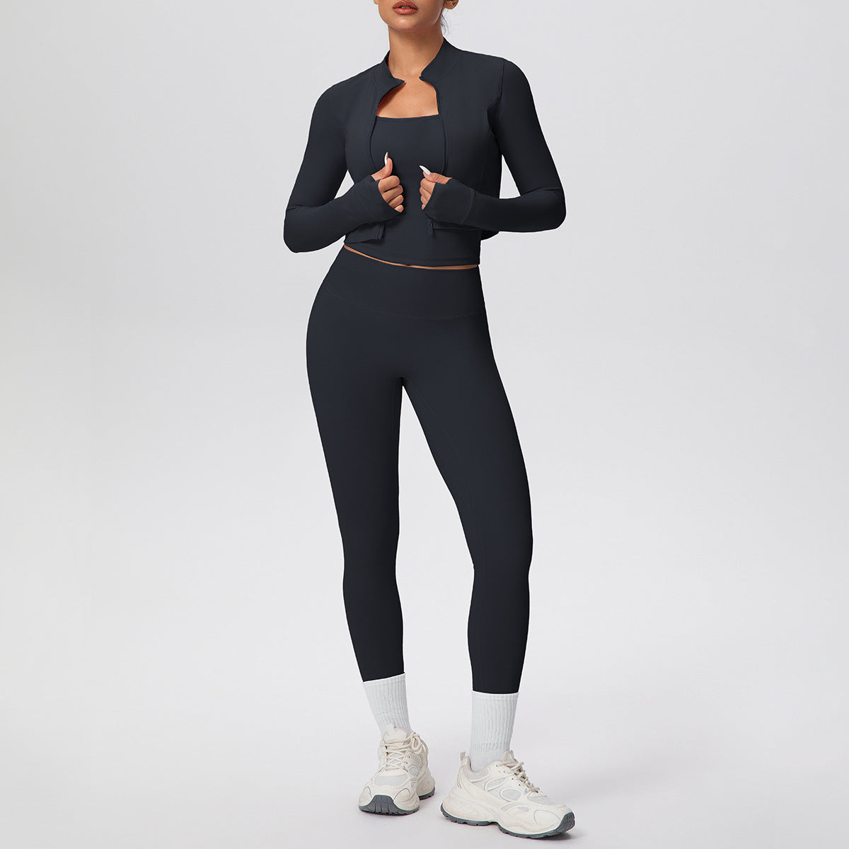 ชุดโยคะ/ฟิตเนส 3 ชิ้น ประกอบด้วย เสื้อแจ็คเก็ตแขนยาวซิปสีพื้น เสื้อกล้ามแบบสายไขว้ และกางเกงโยคะทรงเข้ารูป